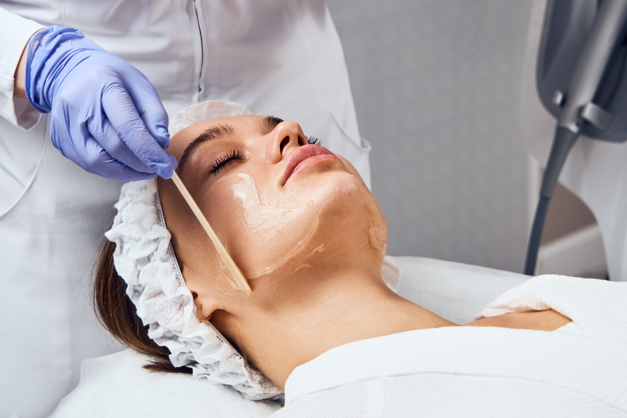 Female patient relaxed at medispa undergoing chemical peel application